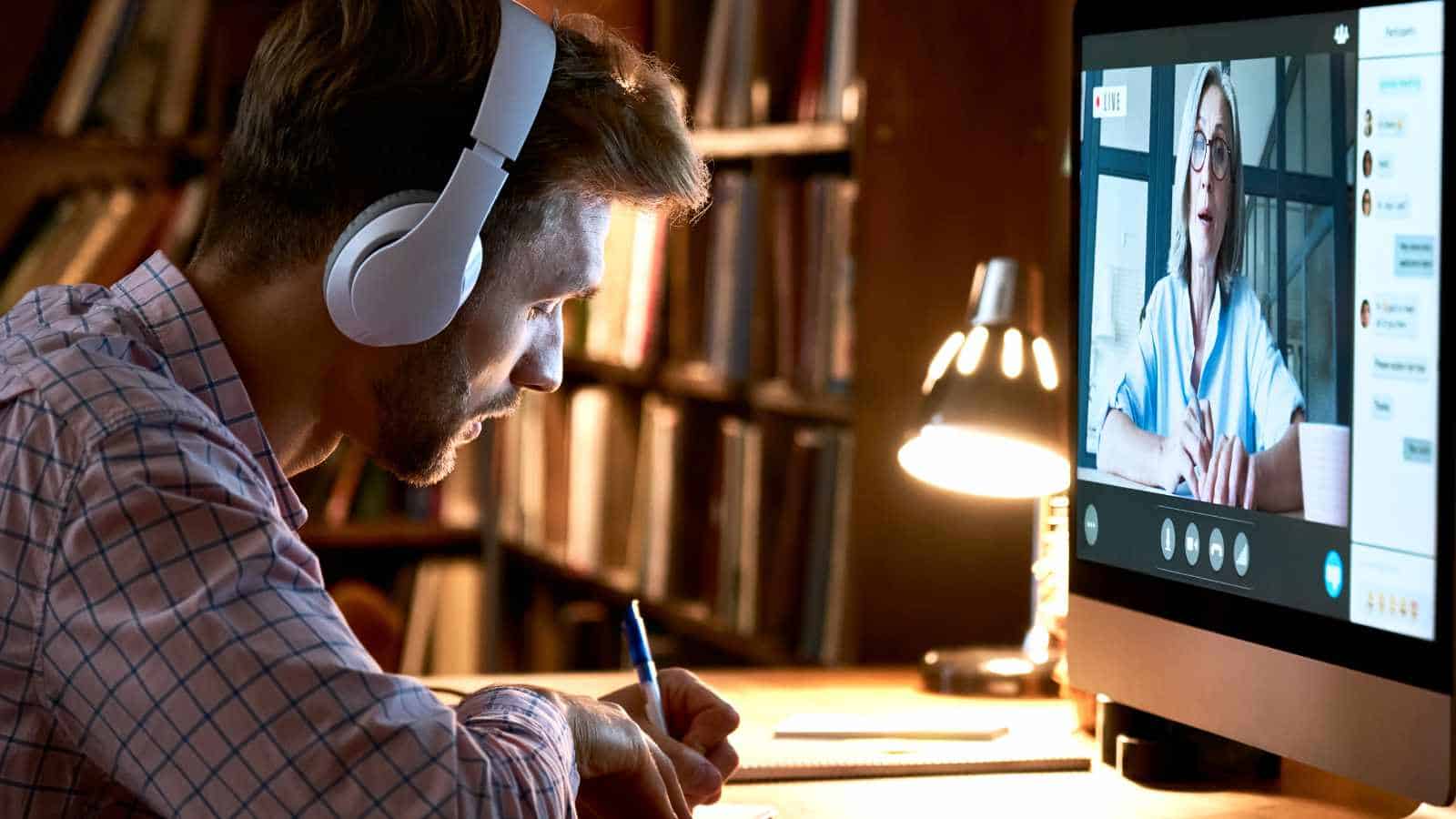 Man participating in a virtual meeting with a healthcare professional on a computer screen.